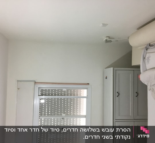 חלון עם תריסים סגורים ותקרה לבנה